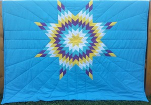 Light Blue Blanket with Yellow, White, Turquoise, Purple, and Yellow Star.