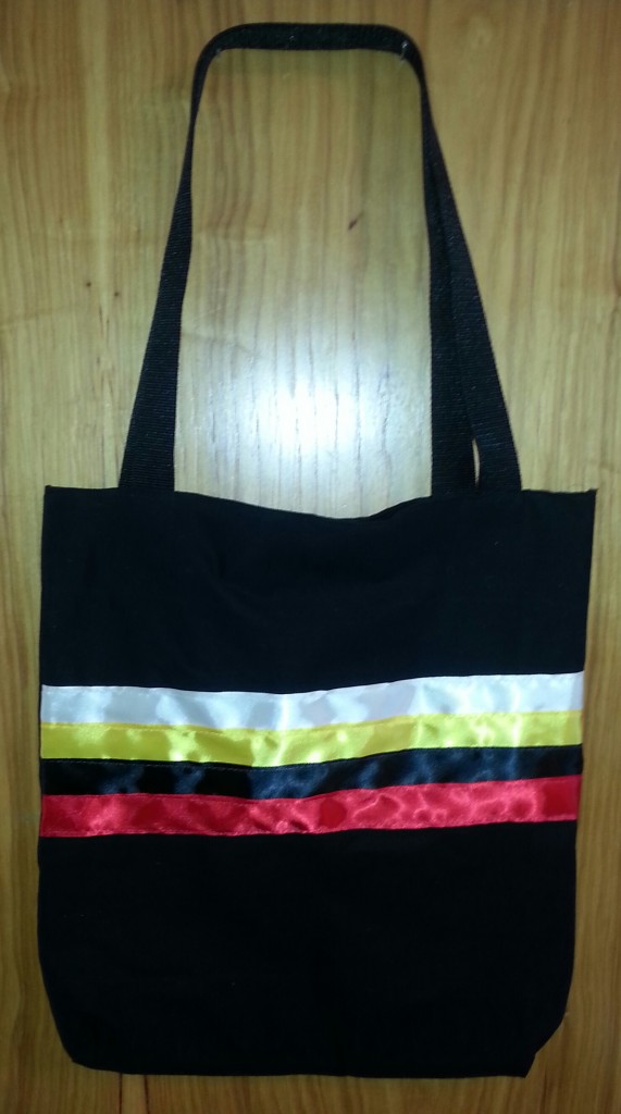 5. Black Bag with White, Yellow, Black and Red Ribbon across the front.